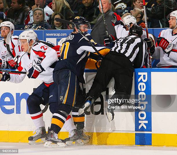 Drew Stafford of the Buffalo Sabres collides with linesman Pierre Champoux while avoiding a check from Alexander Semin of the Washington Capitals on...