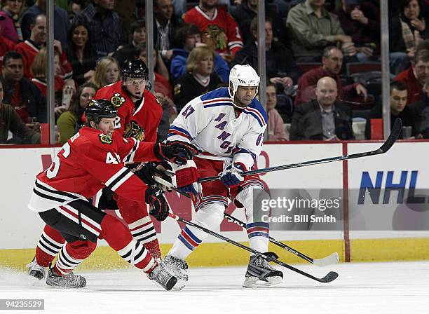 Donald Brashear of the New York Rangers, Colin Fraser and Tomas Kopecky of the Chicago Blackhawks chase after the puck on December 09, 2009 at the...