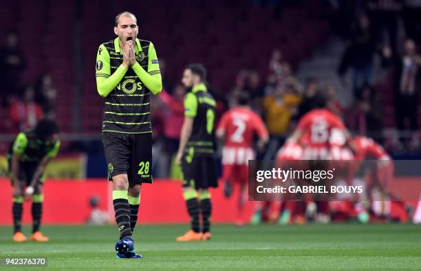 Sporting's Dutch forward Bas Dost gestures as Atletico players celebrate their opening goal during the UEFA Europa League quarter-final first leg...