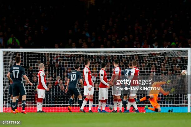 Moscow's Russian midfielder Aleksandr Golovin watches his freekick beat Arsenal's Czech goalkeeper Petr Cech to make the score 1-1 during the UEFA...