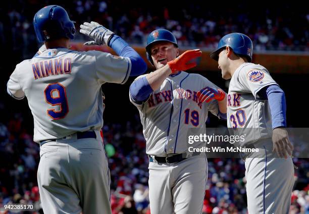 Outfielder Jay Bruce of the New York Mets celebrates with teammates Brandon Nimmo and Michael Conforto after hitting a grand slam in the seventh...