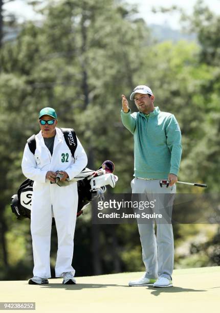 Bernd Wiesberger of Austria lines up a putt on the 18th green with caddiw Shane Koeries during the first round of the 2018 Masters Tournament at...