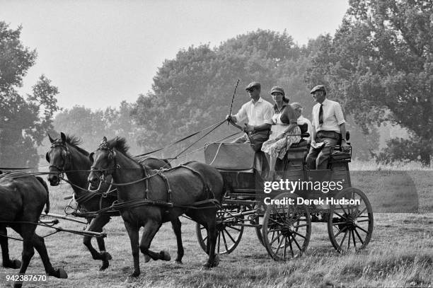 Prince Philip, Duke of Edinburgh drives a team of four horses during a carriage event, Penrith, England, July 1975. The other people with him are...