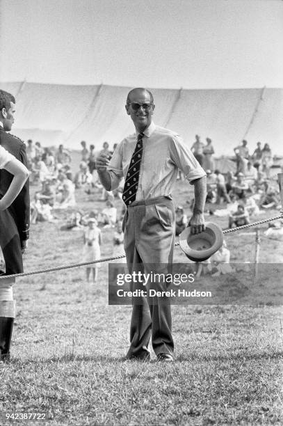 View of Prince Philip, Duke of Edinburgh, a top hat in his hand, as he smiles during a carriage driving event, Penrith, England, July 1975.