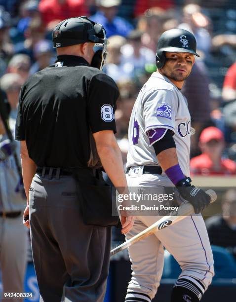 Gerardo Parra of the Colorado Rockies looks back at home plate umpire Mike Estabrook after striking out during the fifth inning of a baseball game...