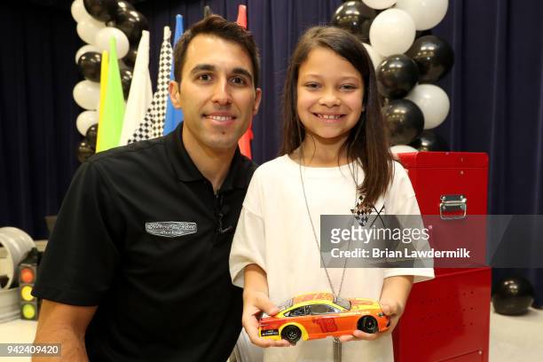 Cup driver Aric Almirola and Mariyah Wortman pose for a photo with the winning car she designed for the Lionel Racing "Design A Die-Cast" at B.B....
