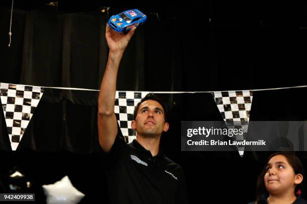 Cup driver Aric Almirola poses for a photo with Alondra Villa of Diamond Hill Elementary School after she won the Lionel Racing "Design A Die-Cast"...