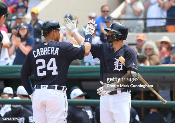 Miguel Cabrera and Nicholas Castellanos of the Detroit Tigers high-five during the Spring Training game against the Atlanta Braves at Publix Field at...