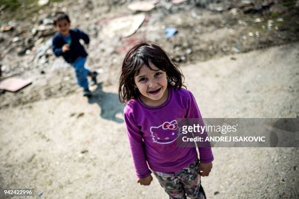 Roma girl named Marija posesfor a photograph at a makeshift camp in Belgrade on March 28, 2018. Bekim Gashi and Kasandra Cac are neighbours in...