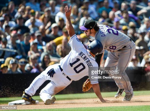 Hunter Renfroe of the San Diego Padres is tagged out at third base by Nolan Arenado of the Colorado Rockies during the seventh inning of a baseball...