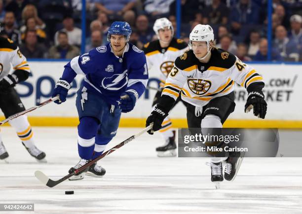 Danton Heinen of the Boston Bruins avoids the defense of Chris Kunitz of the Tampa Bay Lightning during the first period of the game at the Amalie...