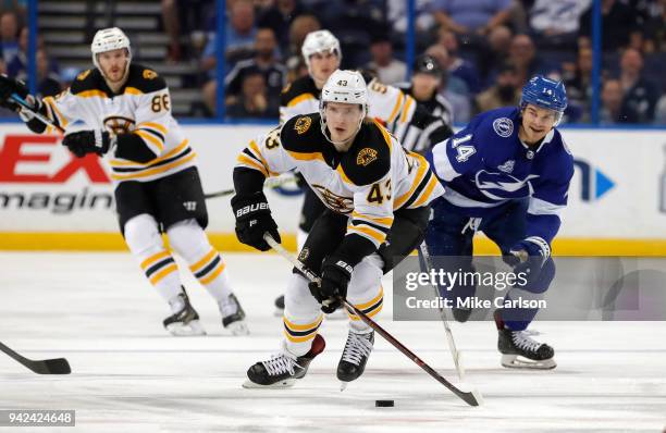 Danton Heinen of the Boston Bruins avoids the defense of Chris Kunitz of the Tampa Bay Lightning during the first period of the game at the Amalie...