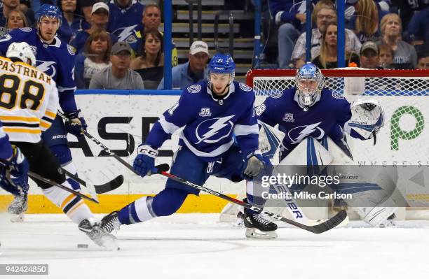 Anthony Cirelli of the Tampa Bay Lightning drops to block a shot from David Pastrnak of the Boston Bruins in front of Andrei Vasilevskiy during the...