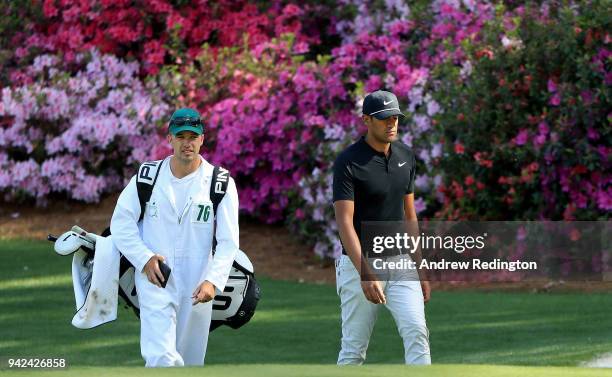 Tony Finau of the United States and caddie Gregory Bodine walk together on the 13th green during the first round of the 2018 Masters Tournament at...