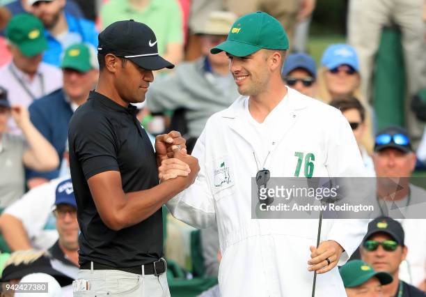 Tony Finau of the United States talks with caddie Gregory Bodine on the 18th green during the first round of the 2018 Masters Tournament at Augusta...