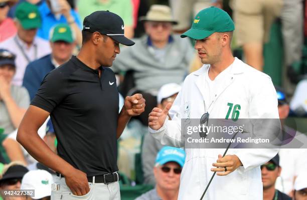 Tony Finau of the United States talks with caddie Gregory Bodine on the 18th green during the first round of the 2018 Masters Tournament at Augusta...