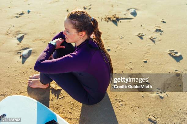 woman sitting on the beach after surfing. - longeville sur mer stock pictures, royalty-free photos & images