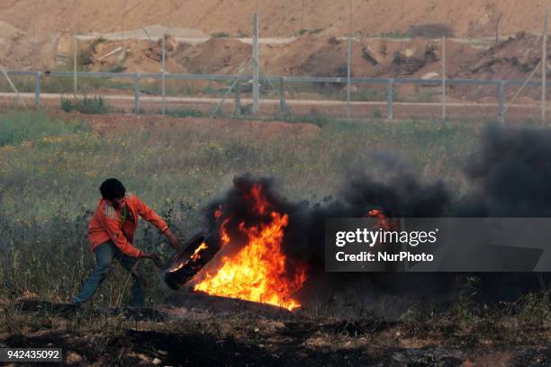 Palestinian protester takes part during clashes with Israeli troops near the border with Israel in the east of Gaza City on, 05 April 2018. One...