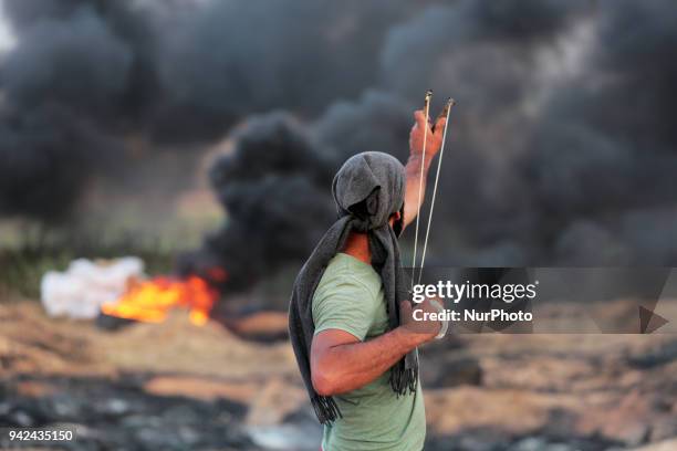 Palestinian protester takes part during clashes with Israeli troops near the border with Israel in the east of Gaza City on, 05 April 2018. One...