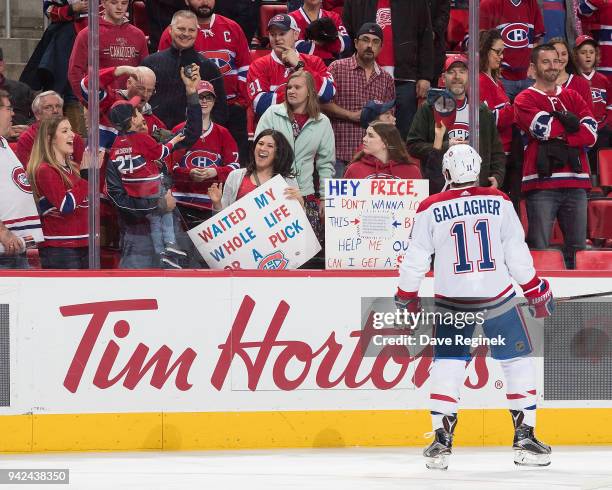 Fan catches a puck given by Brendan Gallagher of the Montreal Canadiens during warm-ups prior to an NHL game against the Detroit Red Wings at Little...