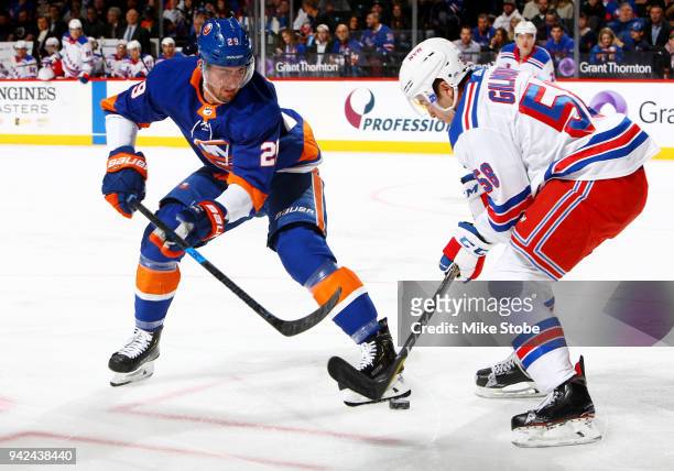 Brock Nelson of the New York Islanders and John Gilmour of the New York Rangers battle for the puck during the first period at Barclays Center on...