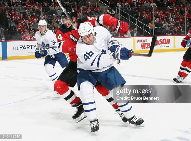 Roman Polak of the Toronto Maple Leafs steps into Miles Wood of the New Jersey Devils during the first period at the Prudential Center on April 5,...