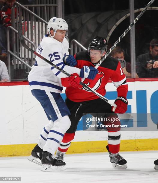 Ben Lovejoy of the New Jersey Devils holds back James van Riemsdyk of the Toronto Maple Leafs during the first period at the Prudential Center on...