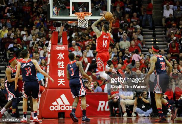 Gerald Green of the Houston Rockets goes up for a dunk defended by Bradley Beal of the Washington Wizards in the second half at Toyota Center on...