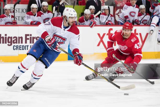 Alex Galchenyuk of the Montreal Canadiens skates with the puck in front of Darren Helm of the Detroit Red Wings during an NHL game at Little Caesars...