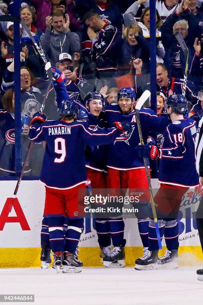 Zach Werenski of the Columbus Blue Jackets is congratulated by his teammates after scoring a goal during the first period of the game against the...