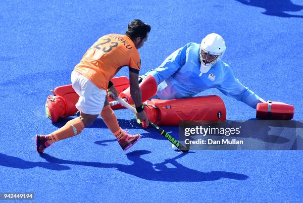 Tengku Tajuddin of Malaysia takes on George Pinner of England during the Hockey Men's Pool B Match between England and Malaysia on day two of the...