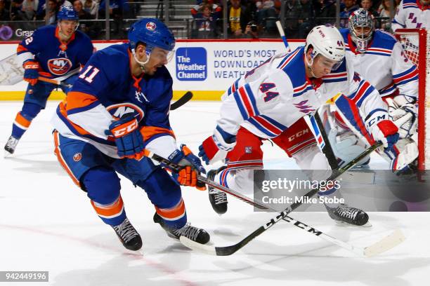 Shane Prince of the New York Islanders and Neal Pionk of the New York Rangers chase down a loose puck during the first period at Barclays Center on...
