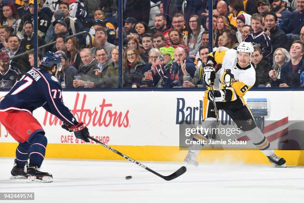 Jamie Oleksiak of the Pittsburgh Penguins passes the puck away from Josh Anderson of the Columbus Blue Jackets during the second period of a game on...