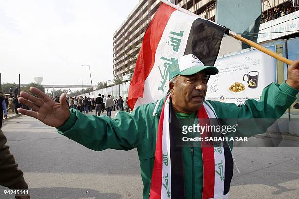 Famous Iraqi football fan Qadduri holds a national flag as he joins Iraqi tribal leaders, athletes and students in a demonstration in Baghdad on...