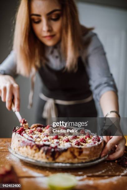 schneiden süße beere torte - woman making cake stock-fotos und bilder