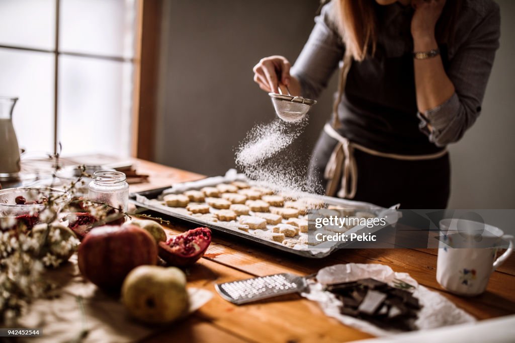 Décorer des biscuits de pain d’épice avec du sucre en poudre