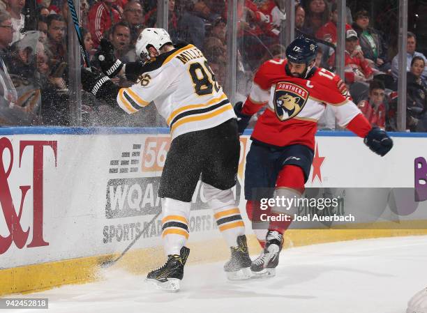 Kevan Miller of the Boston Bruins and Derek MacKenzie of the Florida Panthers battle for control of the puck at the BB&T Center on April 5, 2018 in...