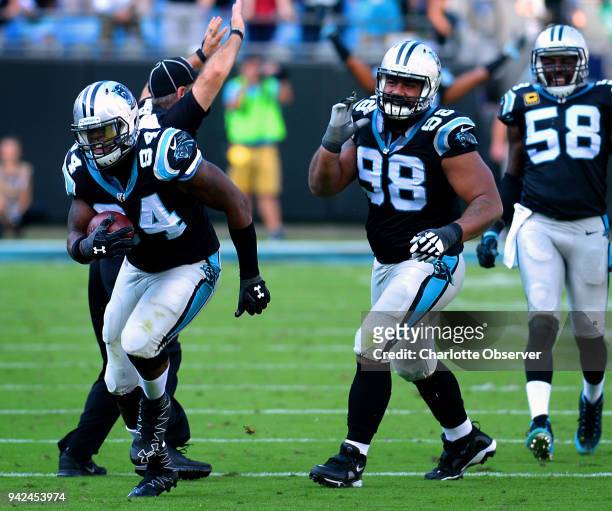 Carolina Panthers defensive end Kony Ealy, left, cradles the ball after intercepting a pass against the Arizona Cardinals on October 30 at Bank of...