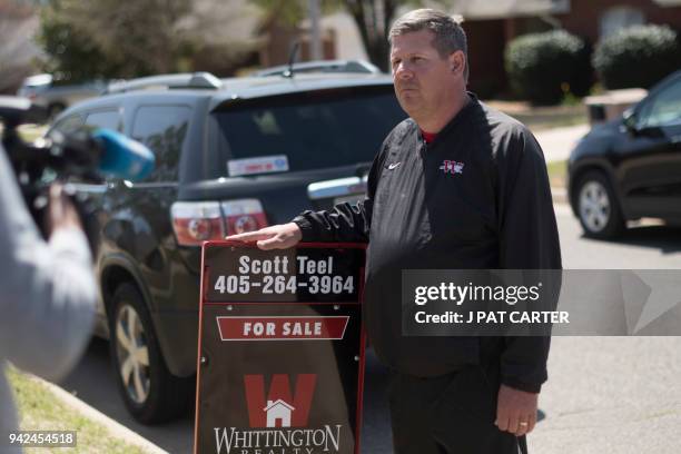 Scott Teel, a high school history teacher, posts a 'for sale' sign, as part of his second job as a real estate agent, in Moore, Oklahoma on April 4,...