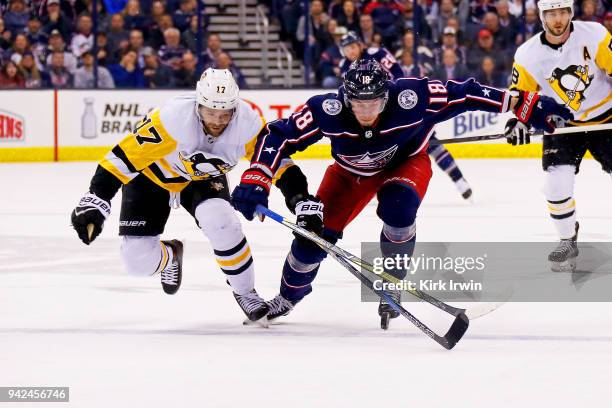 Bryan Rust of the Pittsburgh Penguins and Pierre-Luc Dubois of the Columbus Blue Jackets chase after a loose puck during the second period on April...