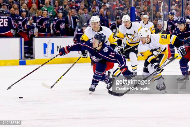 Matt Calvert of the Columbus Blue Jackets is hit with a high stick by Jamie Oleksiak of the Pittsburgh Penguins while attempting to skate the puck...