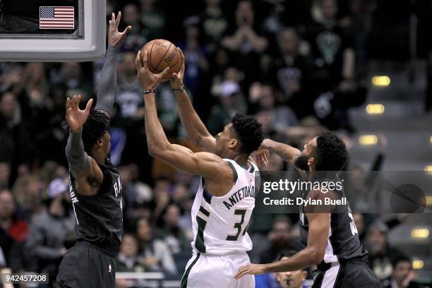 Giannis Antetokounmpo of the Milwaukee Bucks attempts a shot while being guarded by Rondae Hollis-Jefferson and Allen Crabbe of the Brooklyn Nets in...