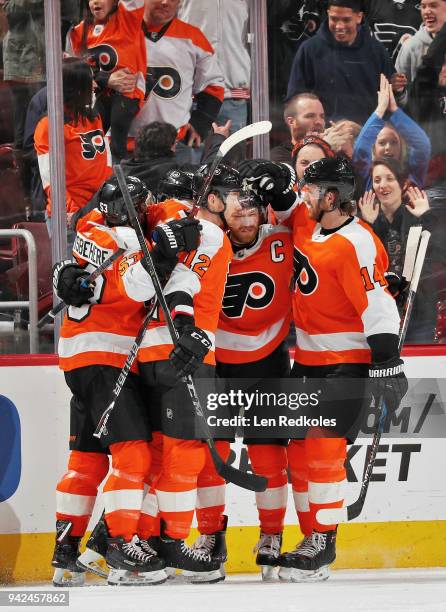 Claude Giroux of the Philadelphia Flyers celebrates his third period goal against the Carolina Hurricanes with Shayne Gostisbehere, Michael Raffl,...