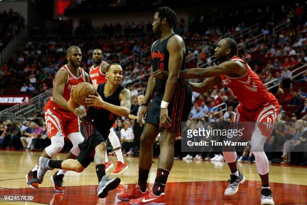 Shabazz Napier of the Portland Trail Blazers drives to the basket defended by Chris Paul of the Houston Rockets and Luc Mbah a Moute in the first...