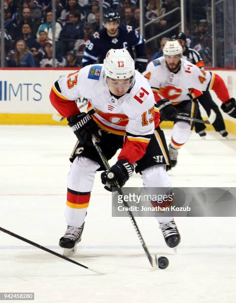 Johnny Gaudreau of the Calgary Flames plays the puck down the ice during first period action against the Winnipeg Jets at the Bell MTS Place on April...