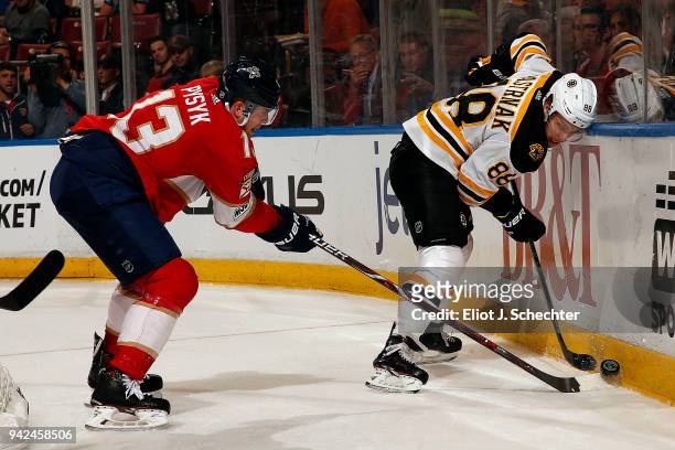 Kevan Miller of the Boston Bruins digs the puck out from the boards against Mark Pysyk of the Florida Panthers at the BB&T Center on April 5, 2018 in...