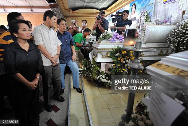 Philippine President Gloria Arroyo views the coffins of slain journalists at the wake in General Santos City, south Cotabato province on December 3,...