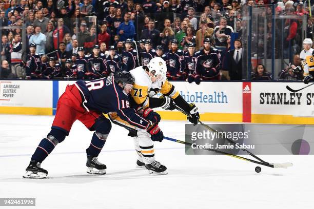 Evgeni Malkin of the Pittsburgh Penguins attempts to keep the puck from Pierre-Luc Dubois of the Columbus Blue Jackets during the overtime period of...