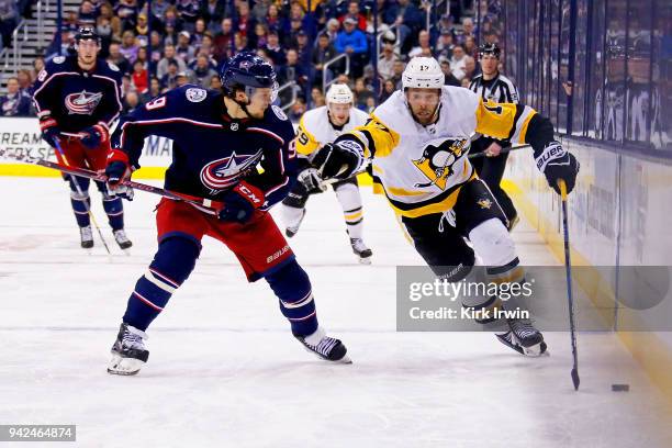 Bryan Rust of the Pittsburgh Penguins attempts to skate the puck past Artemi Panarin of the Columbus Blue Jackets during the third period on April 5,...