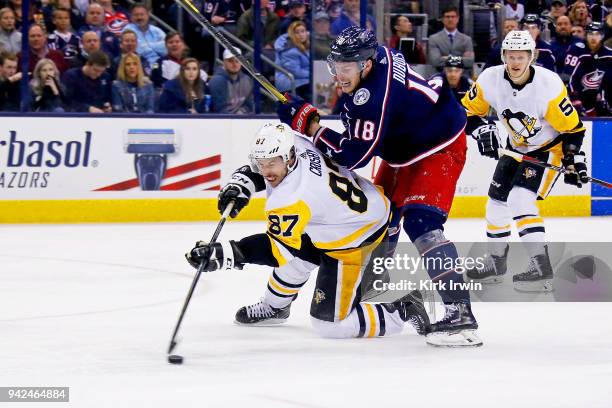 Sidney Crosby of the Pittsburgh Penguins and Pierre-Luc Dubois of the Columbus Blue Jackets battle for control of the puck during the third period on...